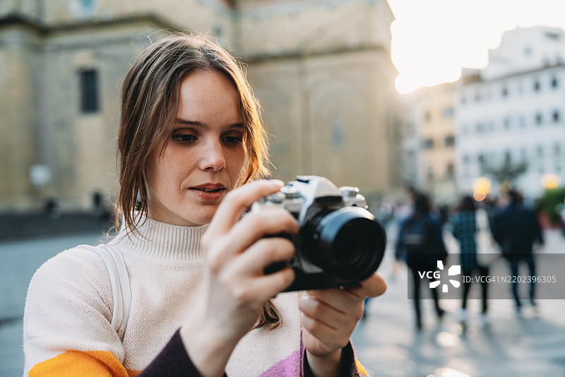 一位女性在日落时分拍摄城市风景图片素材
