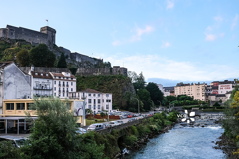 法国奥克西塔尼大区上比利牛斯的卢尔德市，背景为城堡堡垒的城市风景图片素材