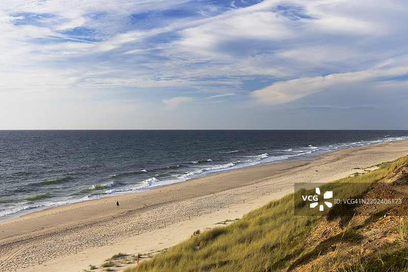 在德国欧洲的西尔特岛坎彭的红崖海滩上行走的人图片素材