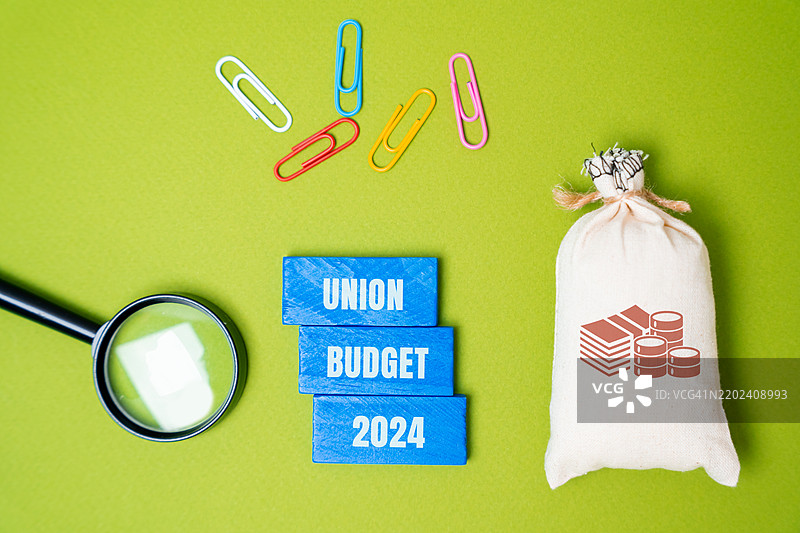 2024年预算概念：由国家政府提交的年度财务报表，详细列出下一年的预期收入和支出。商业与金融，钱袋积木。图片素材