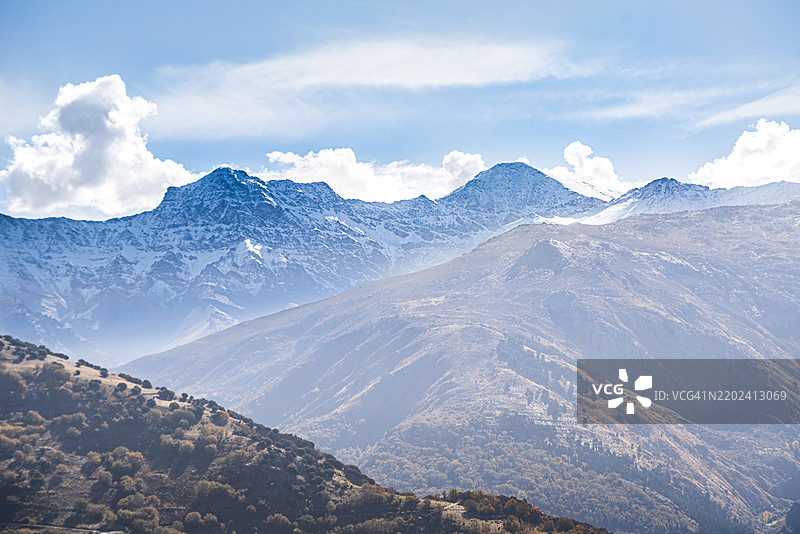 从格哈尔·西耶拉（Guejar Sierra）俯瞰的雪-covered内华达山脉全景，包含阿尔卡萨巴（Alcazaba）和穆尔哈森（Mulhacen），西班牙安达卢西亚格拉纳达地区。图片素材