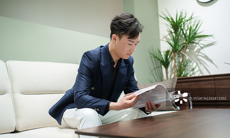 商人坐在沙发上阅读一本书图片素材