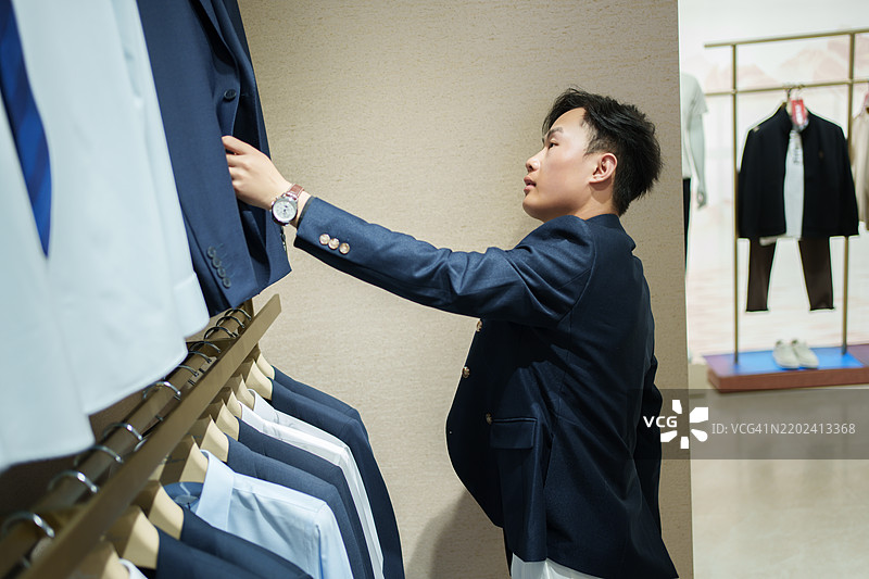 男子在男装店挑选衣服图片素材