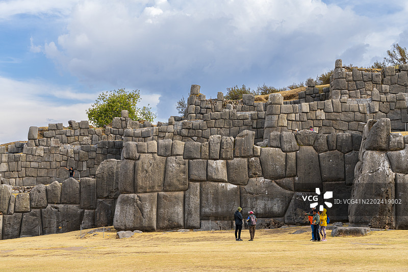 游客在秘鲁南美库斯科地区的萨克赛瓦曼考古遗址的石墙前，联合国教科文组织世界遗产。图片素材