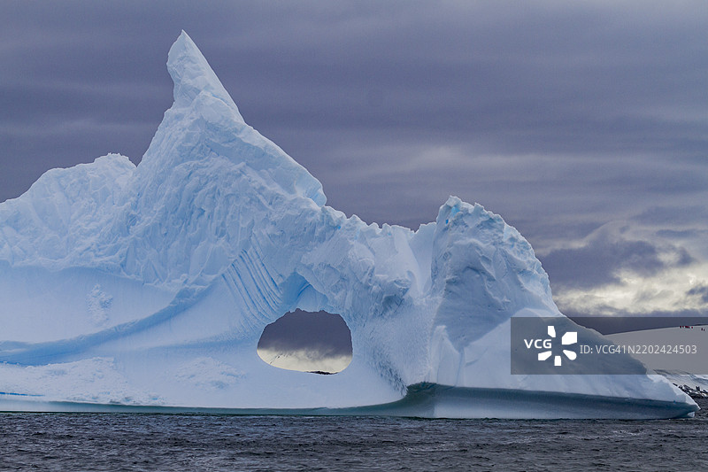 冰山中不寻常的窗户形状，背景是南极半岛西侧的布斯岛，南极，极地地区图片素材
