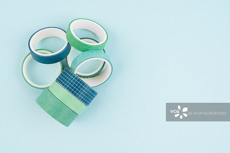 五彩缤纷的和纸胶带卷在蓝色背景上，留有空白空间。图片素材