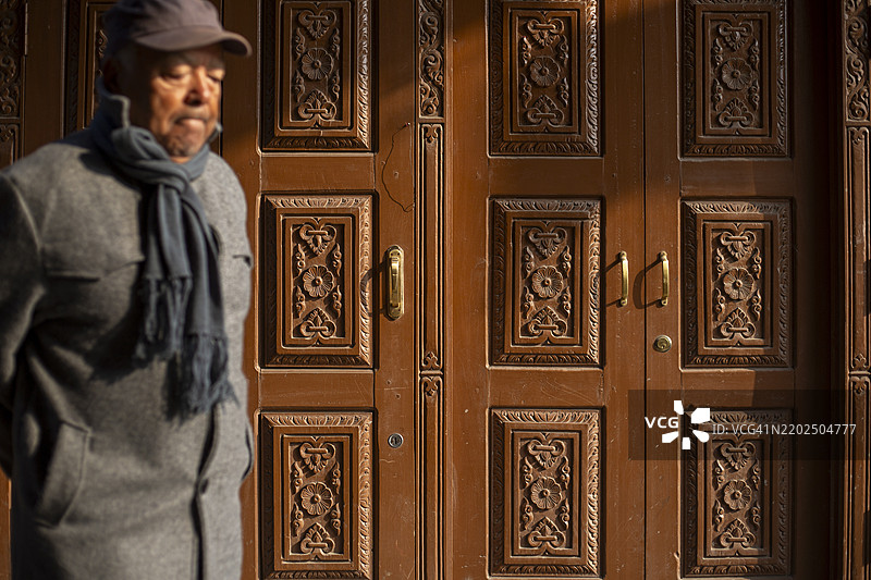 一个人走过尼泊尔加德满都帕坦杜巴广场附近的新ar建筑。图片素材