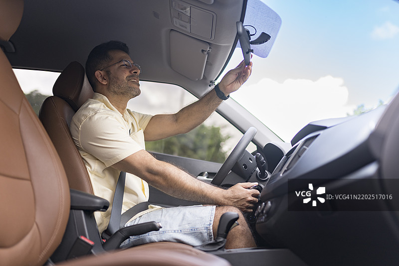 男子调整汽车后视镜图片素材