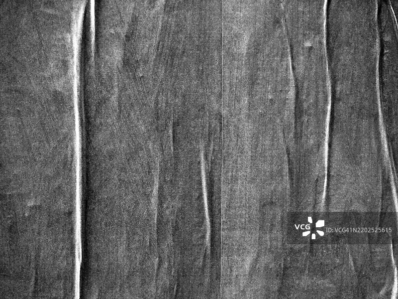 蒙特利尔，魁北克，加拿大墙上贴着的皱纹灰色海报特写。粗糙的纹理。阳光。黑白色。图片素材