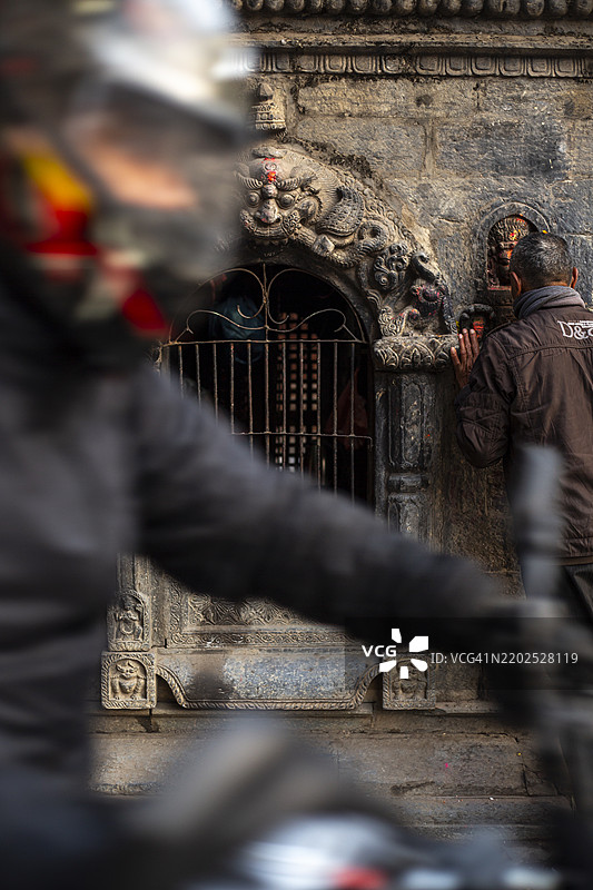 朝圣者在尼泊尔加德满都的帕坦杜巴广场附近的寺庙进行仪式。图片素材