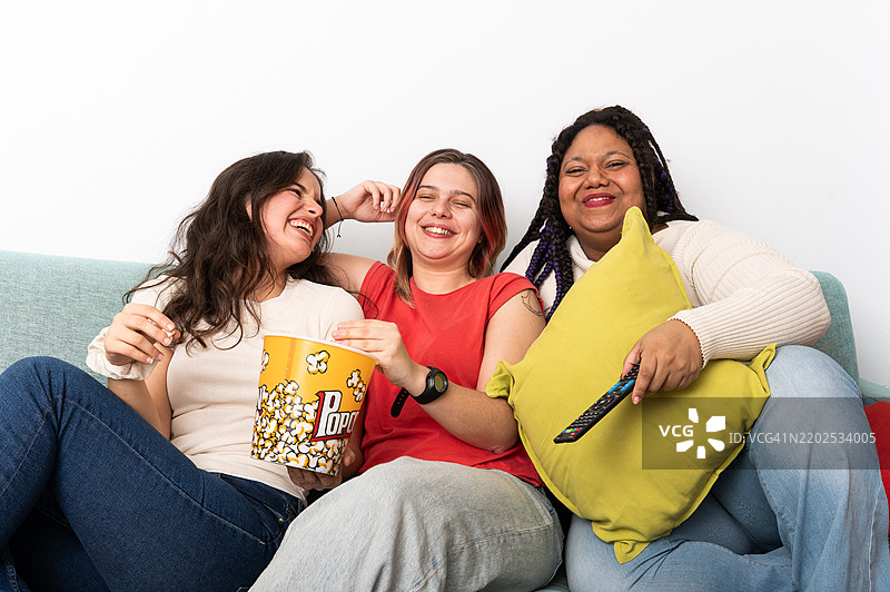 年轻女性们在电影之夜中欢笑并享受爆米花图片素材