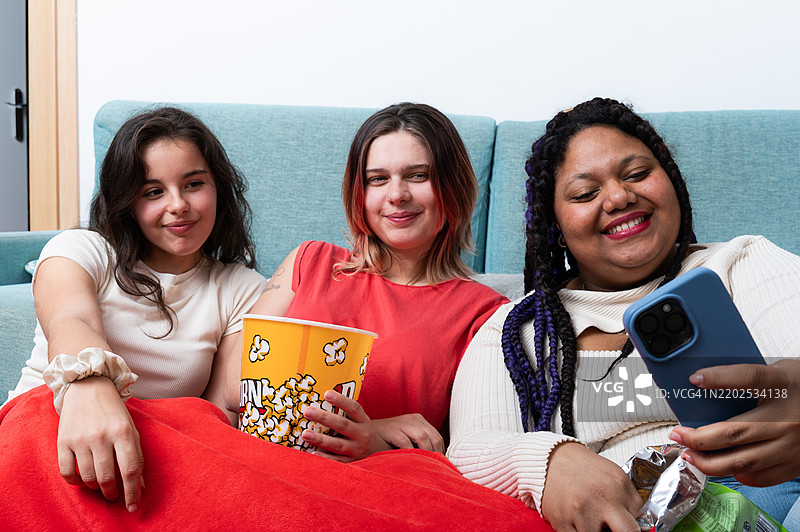 年轻女性在家看电影时自拍图片素材