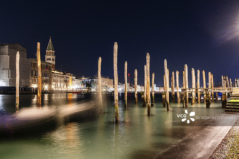 威尼斯的贡多拉，停靠在大运河的海关办公室，贡多拉特拉盖托·多加纳，后方是钟楼，长时间曝光，夜景，意大利威尼托，欧洲图片素材