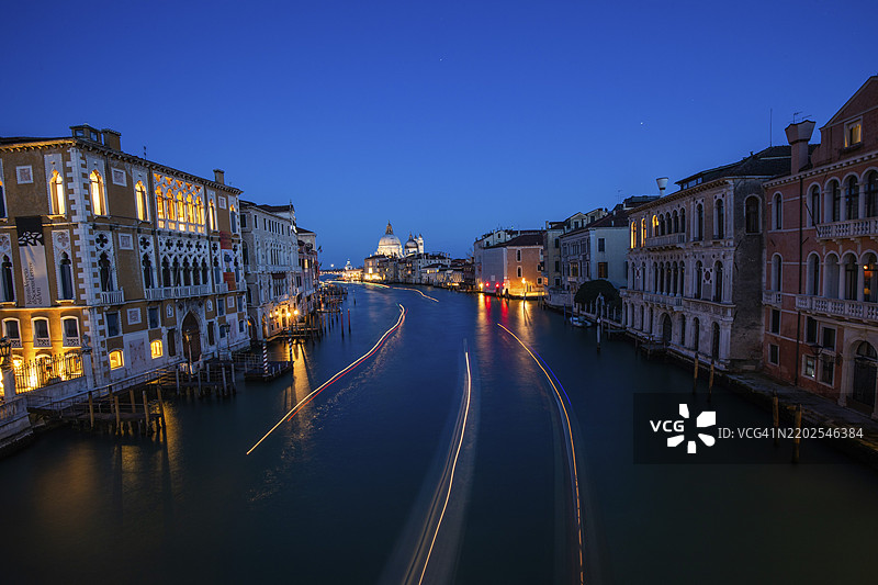 从学院桥俯瞰大运河和圣玛丽亚·德拉·萨卢特大教堂，光轨，长时间曝光，蓝色时刻，威尼斯，意大利，欧洲图片素材