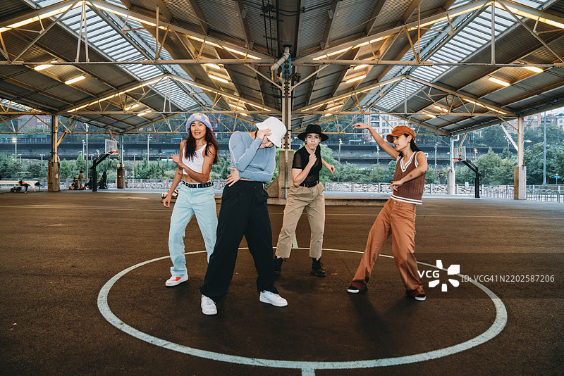 街头舞者在篮球场中央跳舞图片素材