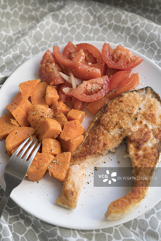 烤三文鱼配红薯和番茄沙拉。健康饮食理念。图片素材