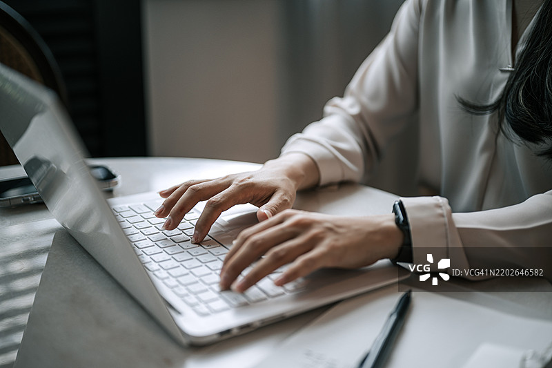 特写的亚洲女性在笔记本电脑上打字图片素材