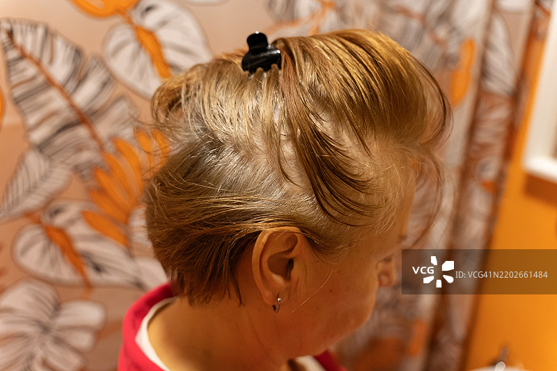 展示时尚发夹发型的老年女性，背景为生动的图案。图片素材