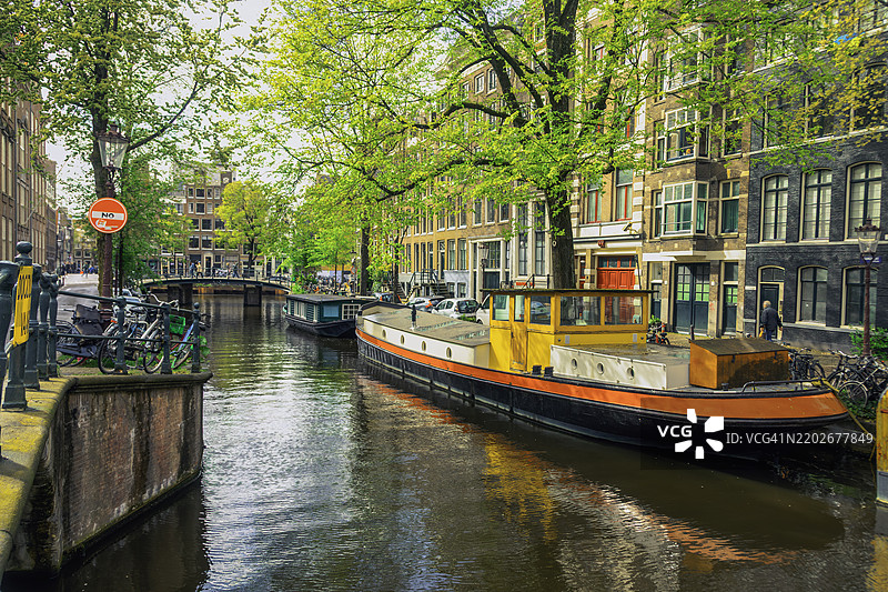 荷兰阿姆斯特丹运河上的春晨与房船图片素材