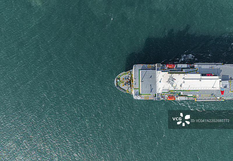 航拍视角，大型船只（船首）驶出货物港口。通过汽车驳船运输到外国，海上运输成品汽车的业务。图片素材