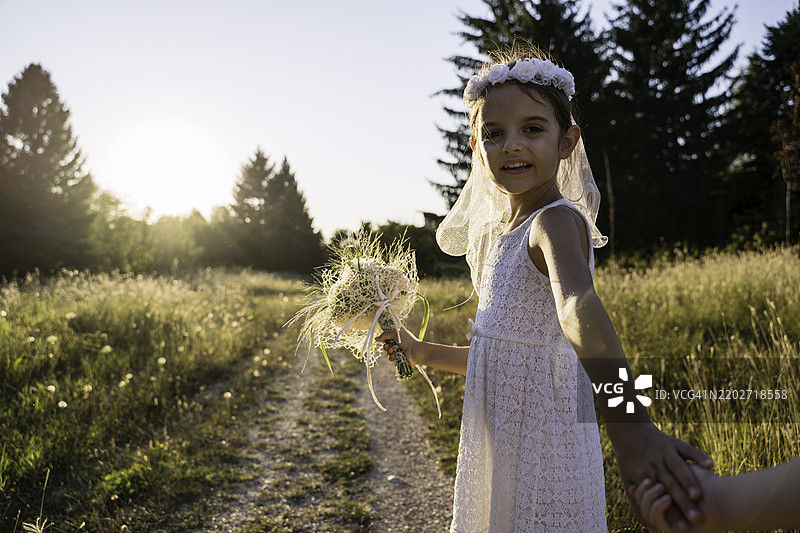 金色日落光线中的年轻女孩与花束图片素材