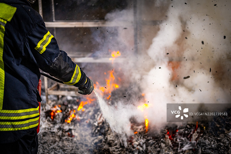 消防员在户外扑灭火焰，伴有烟雾和火花图片素材