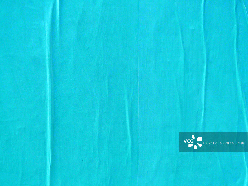 浅蓝色纸张背景粘贴在墙上并且皱褶。图片素材