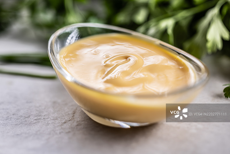 用鸡蛋、芥末、葵花籽油和盐手工制作的蛋黄酱，盛在玻璃碗中图片素材