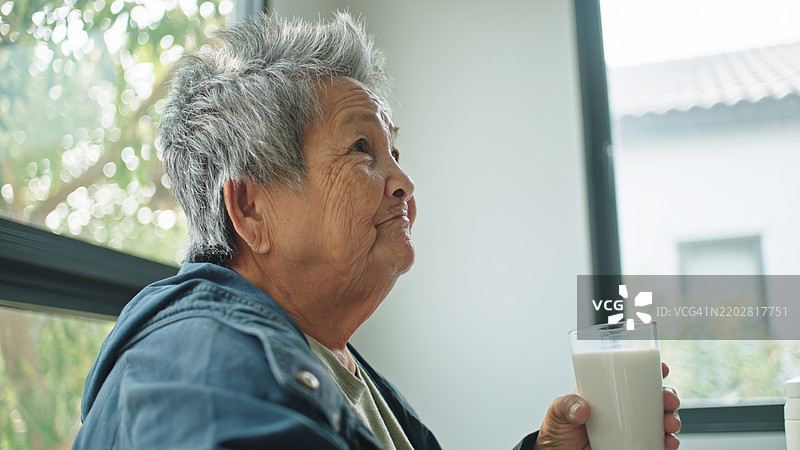 老人喝牛奶。图片素材