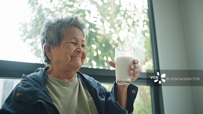 老人喝牛奶。图片素材