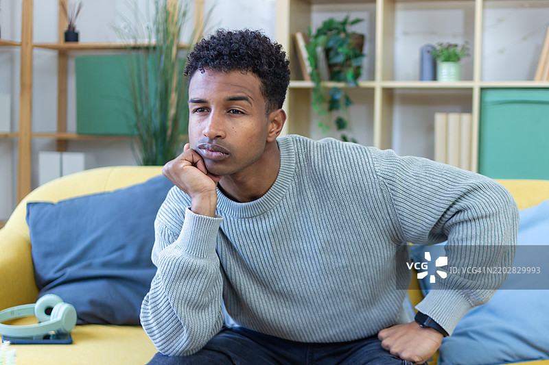 年轻男子在沙发上感到无聊图片素材