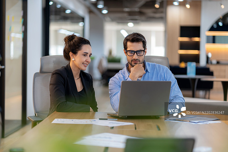 商人在现代办公室向女高管展示市场数据和工作计划分析，以便进行战略决策和未来业务发展。图片素材