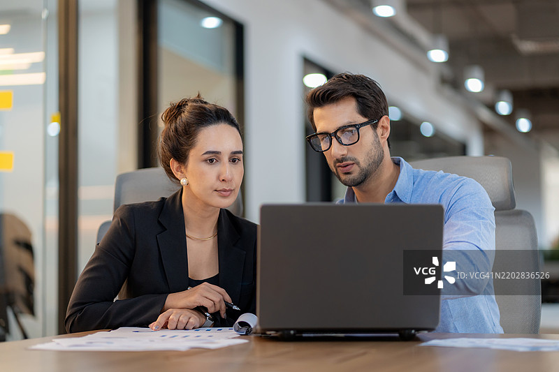 未来商业规划与数据驱动的洞察。一位男性项目负责人与一支多元化的女性团队在高科技办公室中讨论财务、战略和创新。企业领导力、协作和数字化转型的实践。图片素材