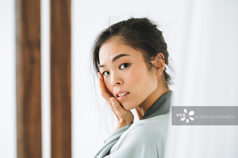 身穿浅蓝色民族和服的美丽年轻日本女性肖像，背景为白色。图片素材