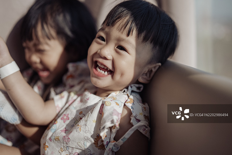 积极情绪的亚洲小情侣，手中拿着静脉输液，感觉好些了。图片素材