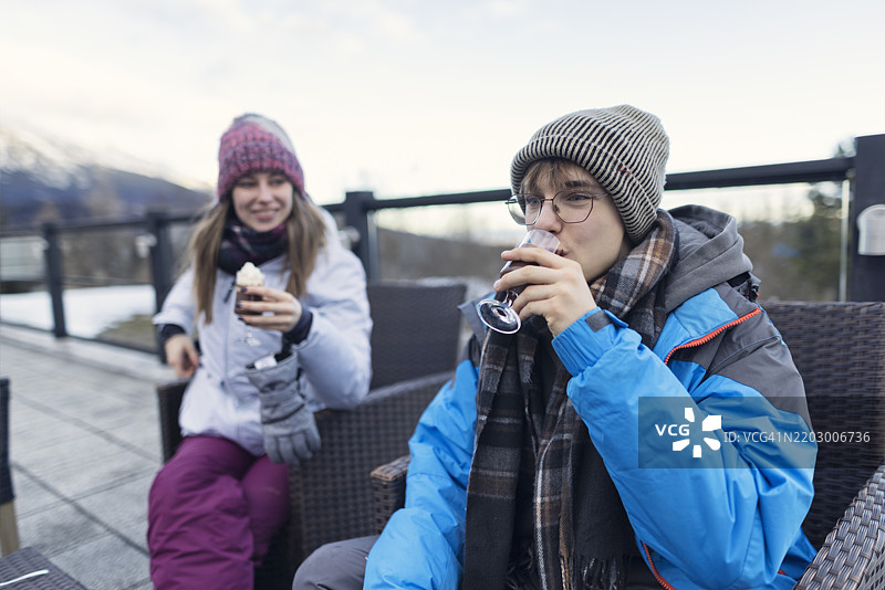 青少年在高塔特拉山的观景露台上喝热巧克力，天气阴沉的冬日。图片素材
