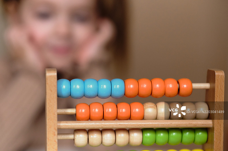 算盘特写，背景中有一个小女孩图片素材