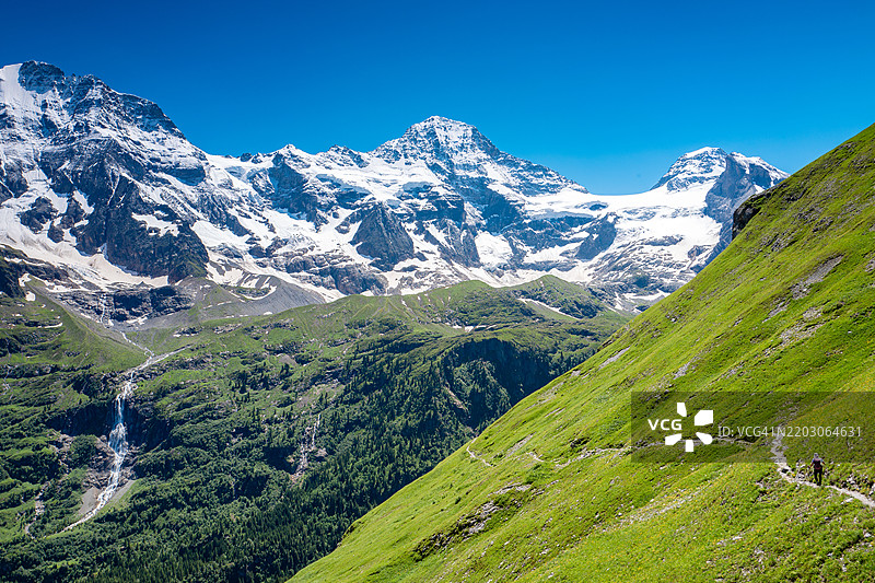 瑞士旅行 - 一名女性在山坡小径上徒步旅行图片素材