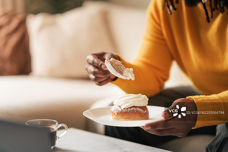 穿着黄色毛衣的男人享受着美味的奶油糕点图片素材