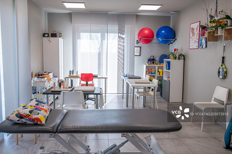 宽敞的物理治疗工作室，配备按摩床和治疗工具，帮助患者康复图片素材