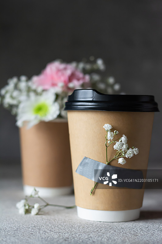 一杯咖啡，拿铁旁边用胶带绑着一小束花。生日、情人节、母亲节的礼物创意。送花礼物的创意。图片素材