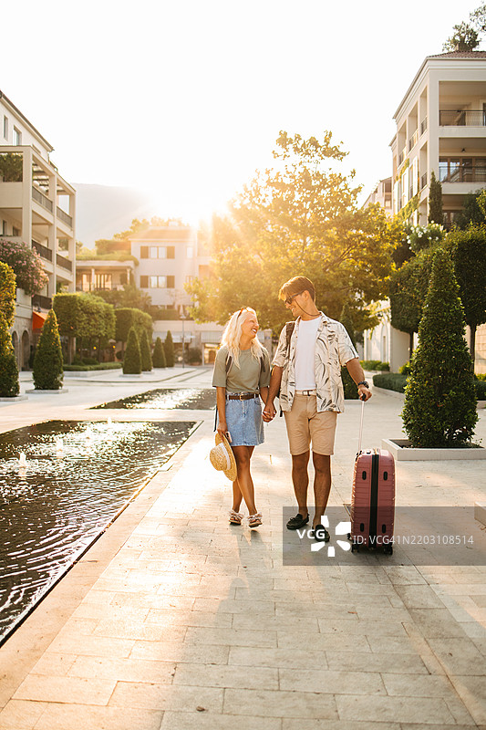 年轻情侣抵达奢华小镇度假图片素材