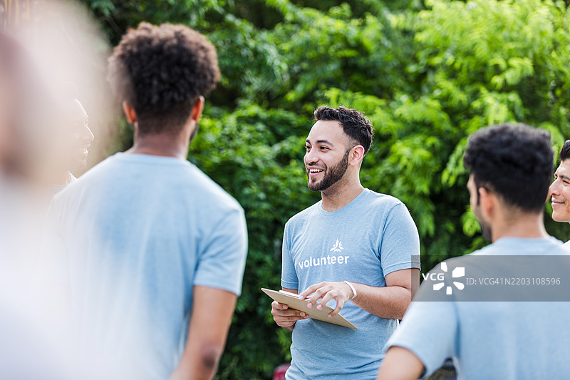 多元化的志愿者团队在户外聚会，微笑交谈图片素材