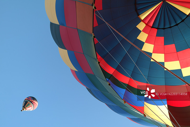 低角度视图的热气球与晴朗的蓝天相映衬图片素材