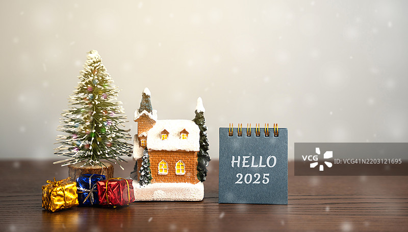 你好，新年2025概念，庆祝新年的开始，圣诞树、礼物和房子，雪花纷飞图片素材