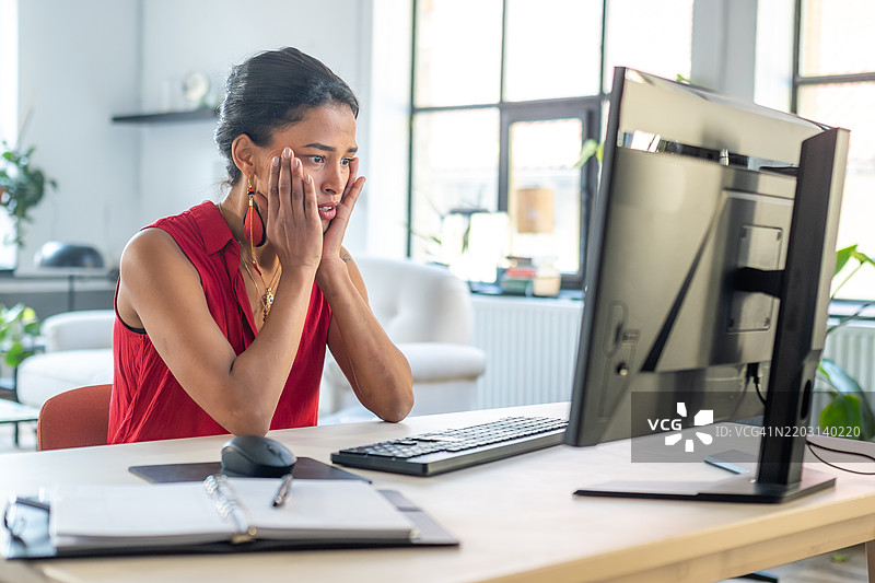 压力大的混血女性在家办公桌前工作图片素材