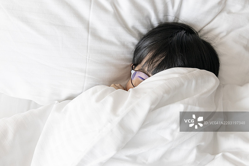 顽皮的小男孩在床上。图片素材