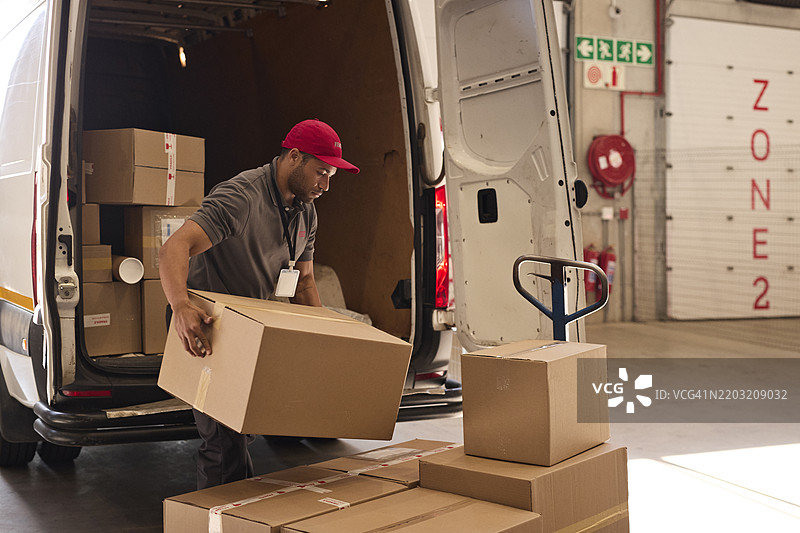仓库工人在卸货纸箱图片素材