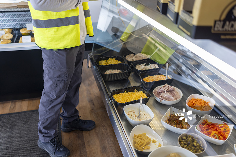 无法辨认的男子在食品柜台前图片素材