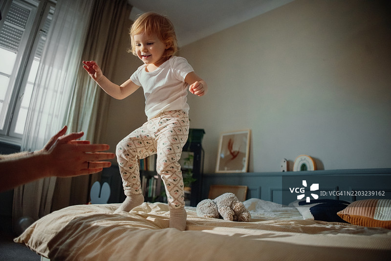 快乐的孩子在明亮现代的卧室里玩耍图片素材